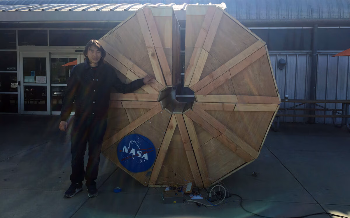 Larry Phong stands beside a NASA-funded deployable Mars habitat prototype at Cal Poly Pomona.
