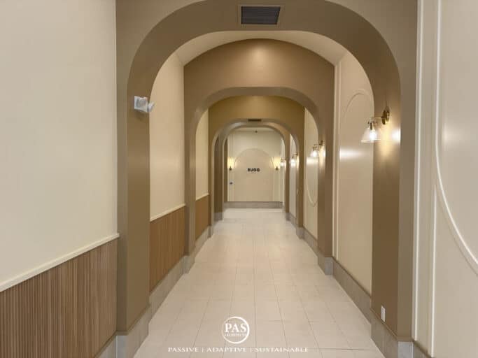 Layered arches and wall sconces in a hallway remodel at Sugo Social restaurant